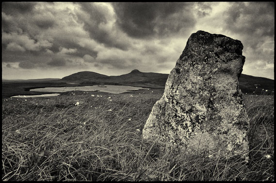 Standing stone with small lochan in the background